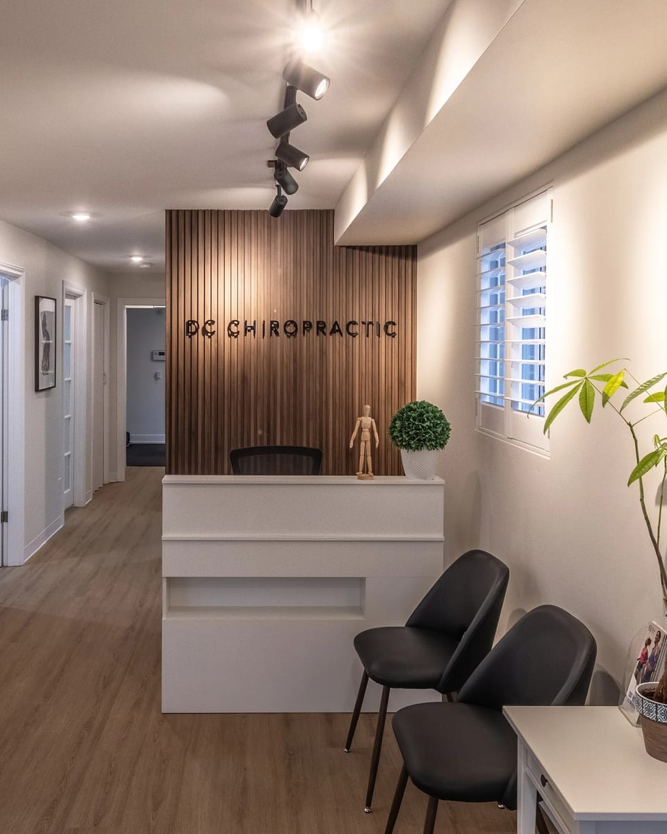 The DC Chiropractic reception desk, with the clinic's name on the slatted walnut wall